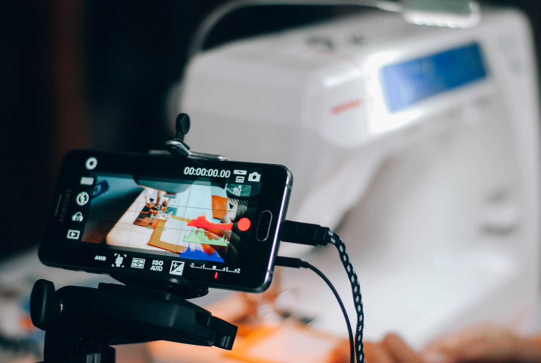 A phone on a tripod filming a craft being made
